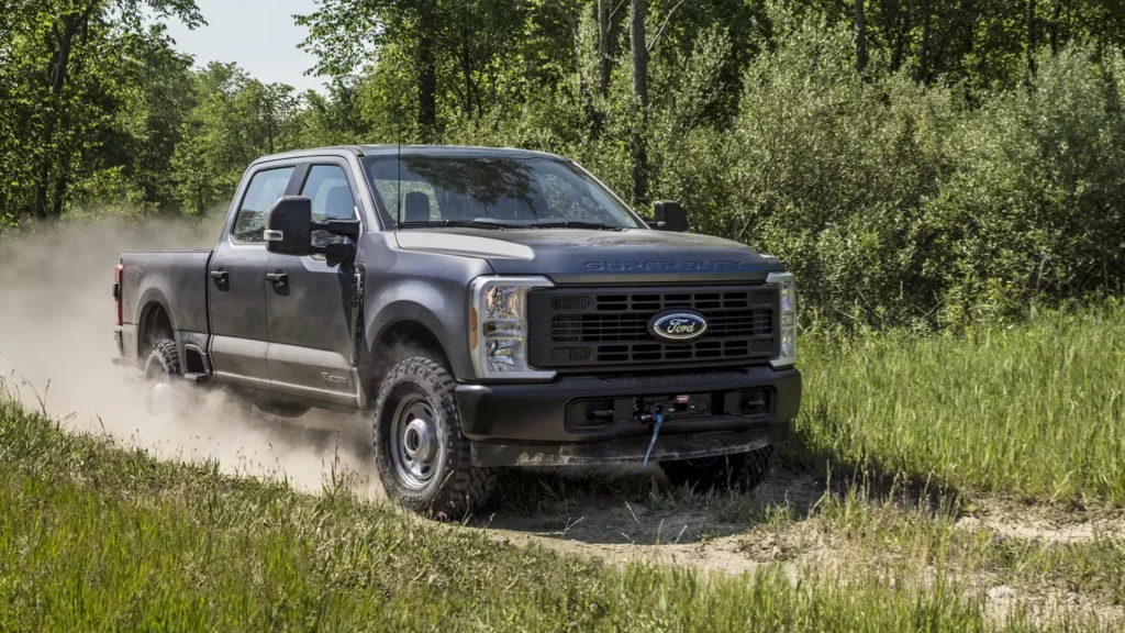Gray 2025 Ford F-250® Super Duty kicking up dust on a grassy off-road trail.