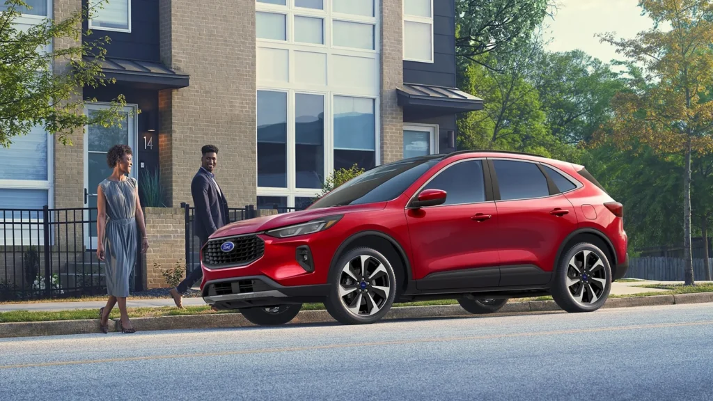 2025 Ford Escape® in red parked curbside in front of a modern residential building.